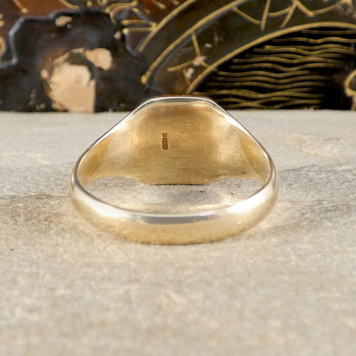 Gold ring on a textured surface with a decorative background