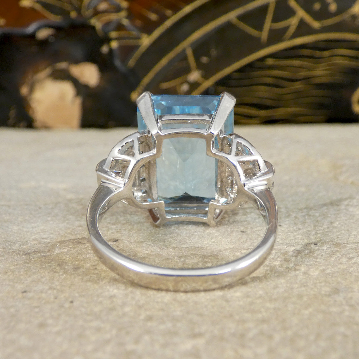 white gold ring with a blue gemstone on a textured surface