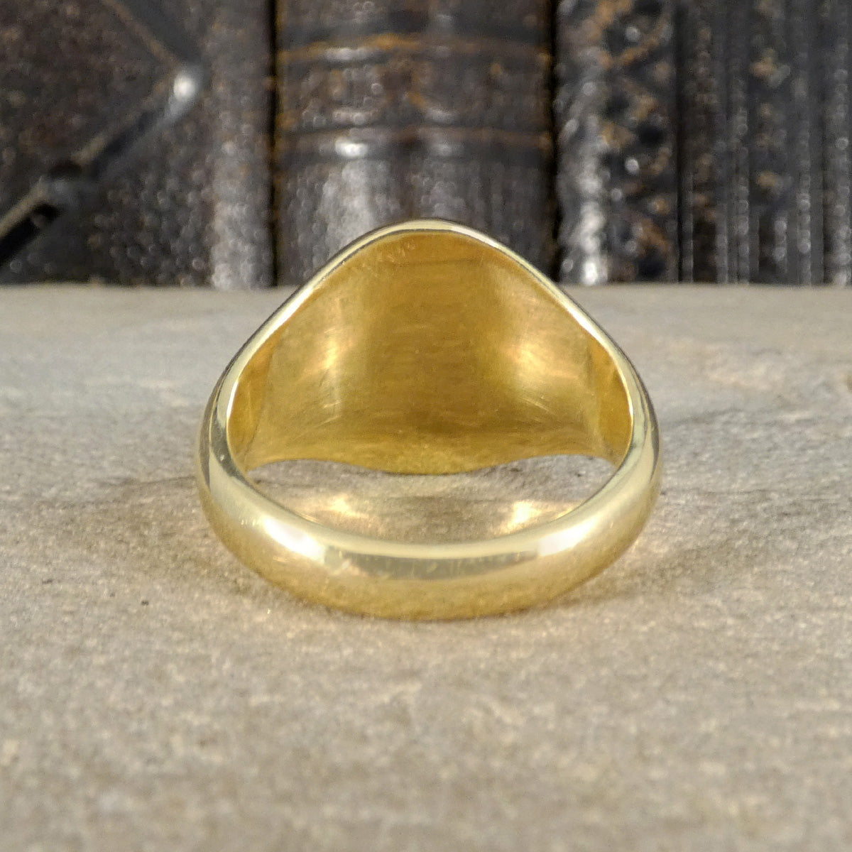 Gold ring on a textured surface with a dark, patterned background