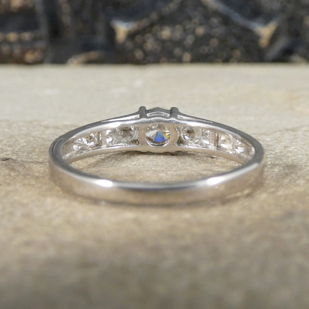 Silver ring with diamonds on a textured surface