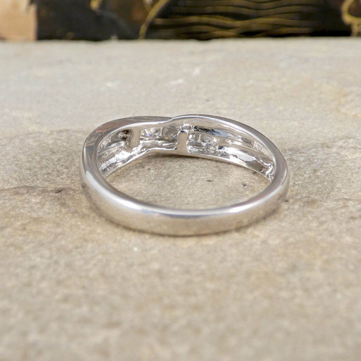 Silver ring with embedded stones on a textured surface