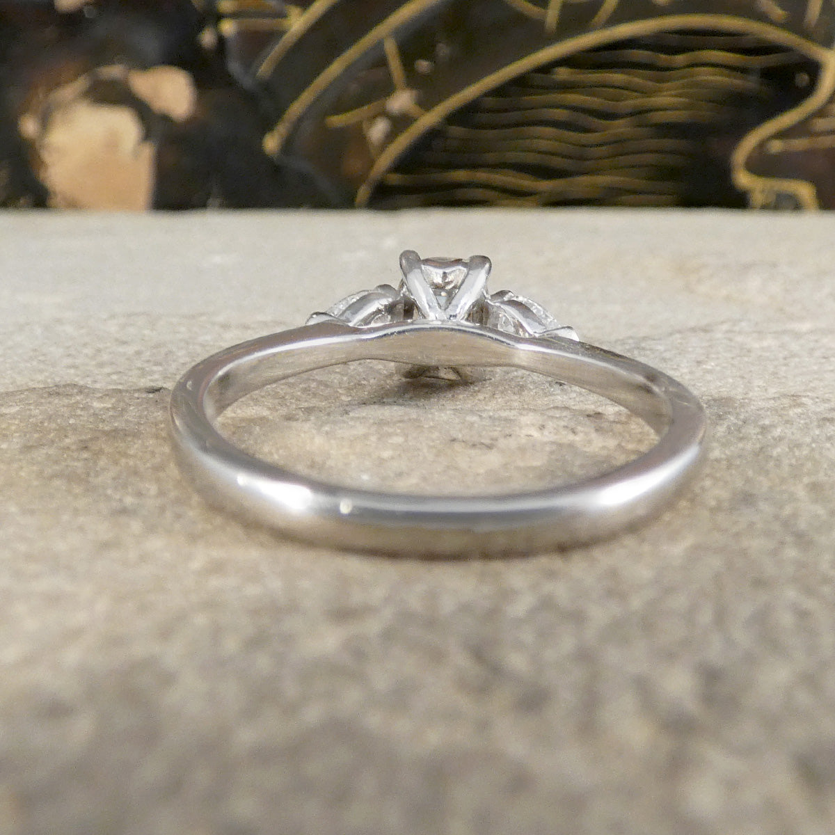 Silver ring with a diamond on a textured surface