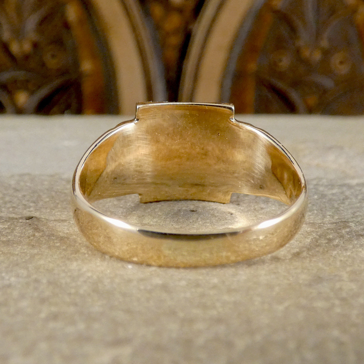 Gold ring on a textured surface with a blurred background