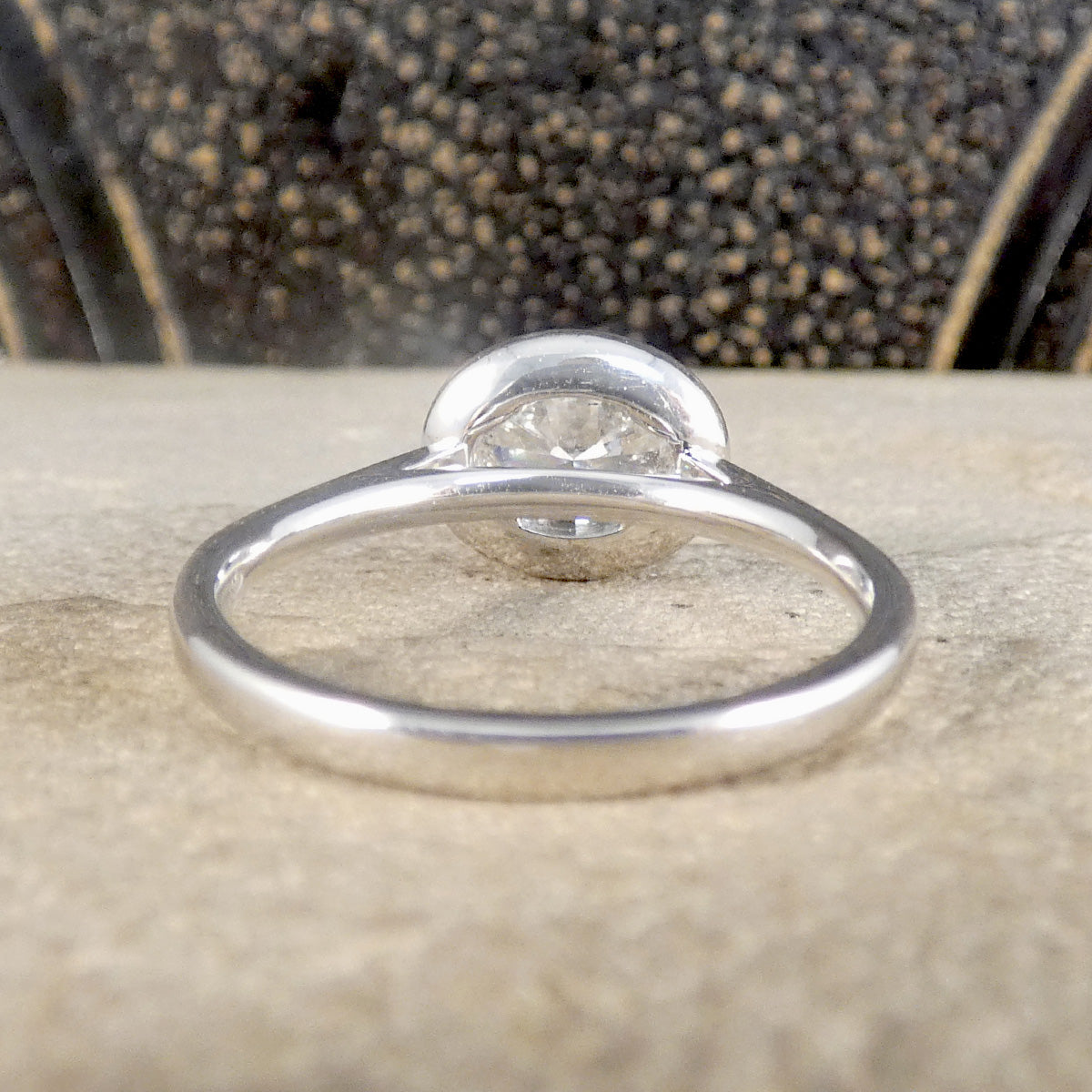 Oval Cut Diamond Ring in a chunky bezel setting set east west. shown from behind