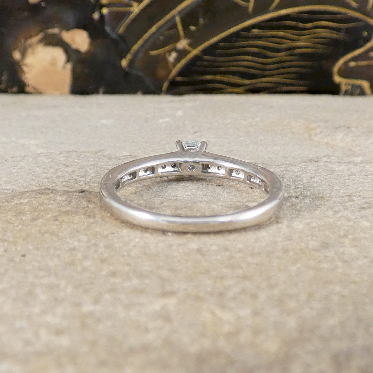 Silver ring with diamonds on a textured surface