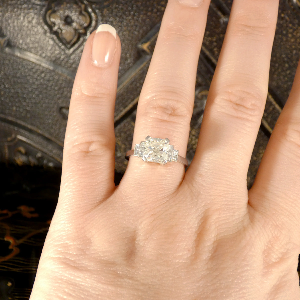 GIA Cert 2.01ct Cushioned Brilliant Cut Diamond Solitaire with Diamond Set Shoulders in Platinum. This beautiful ring is displayed on the ring finger showing the size ratio and how it would be a perfect engagement ring.