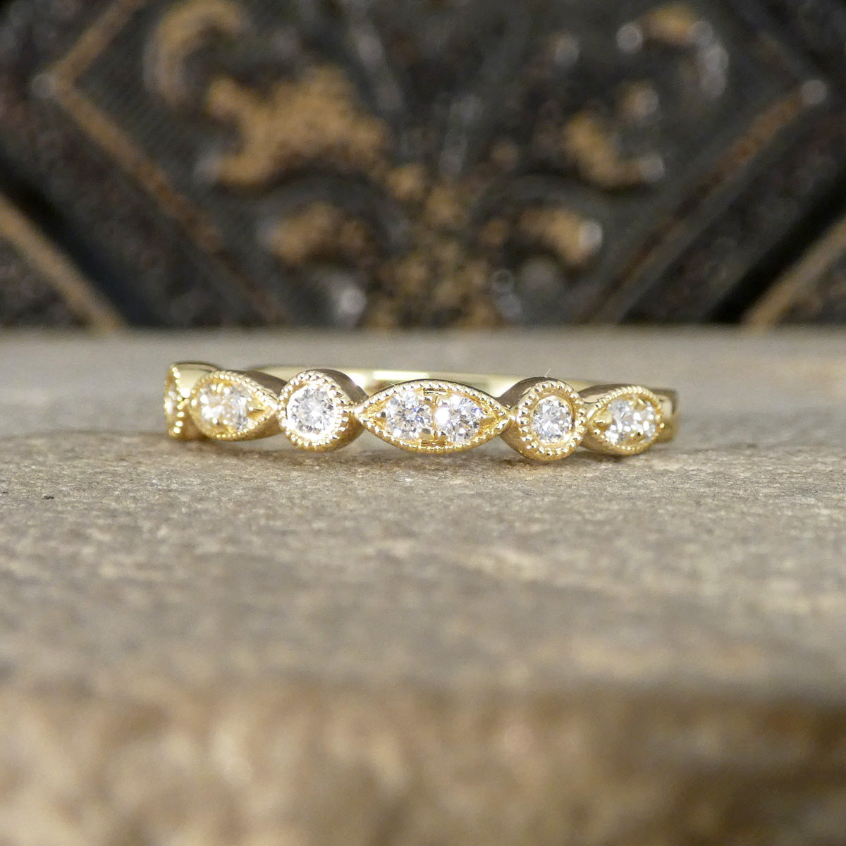 Gold ring with diamonds on a textured surface