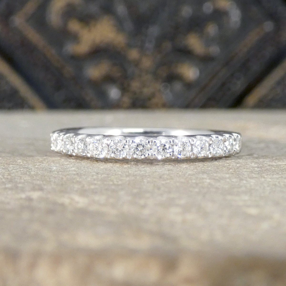 Platinum eternity ring with small diamonds on a textured surface