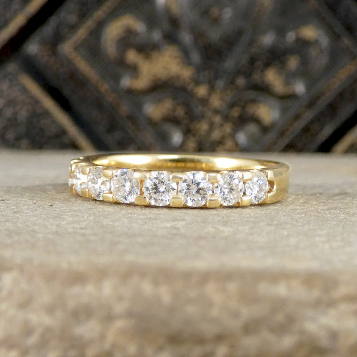 Gold ring with diamonds on a textured surface