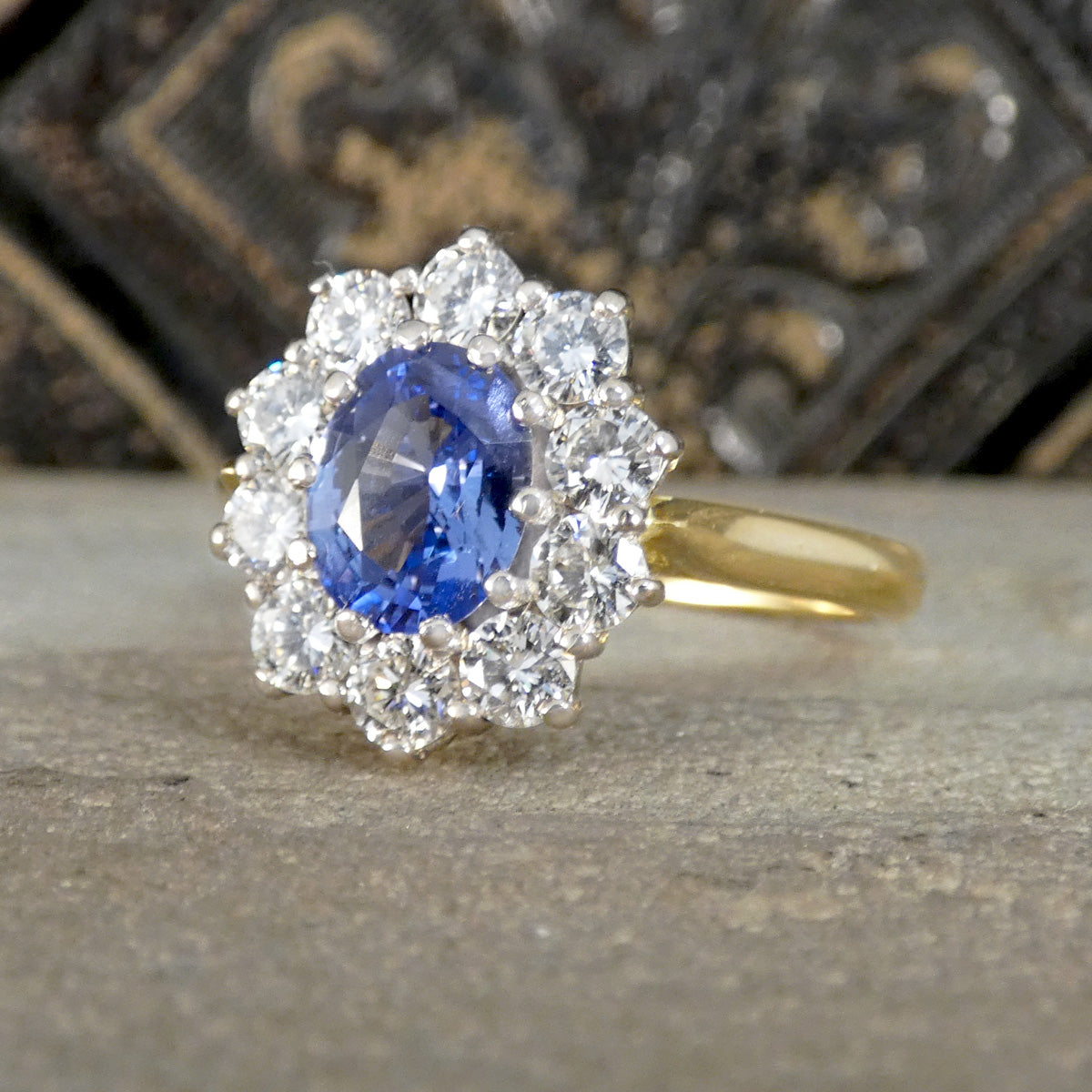 Ring with blue sapphire gemstone and diamond halo on a textured surface