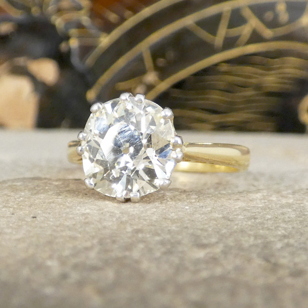 Gold ring with a large old cut diamond on a textured surface