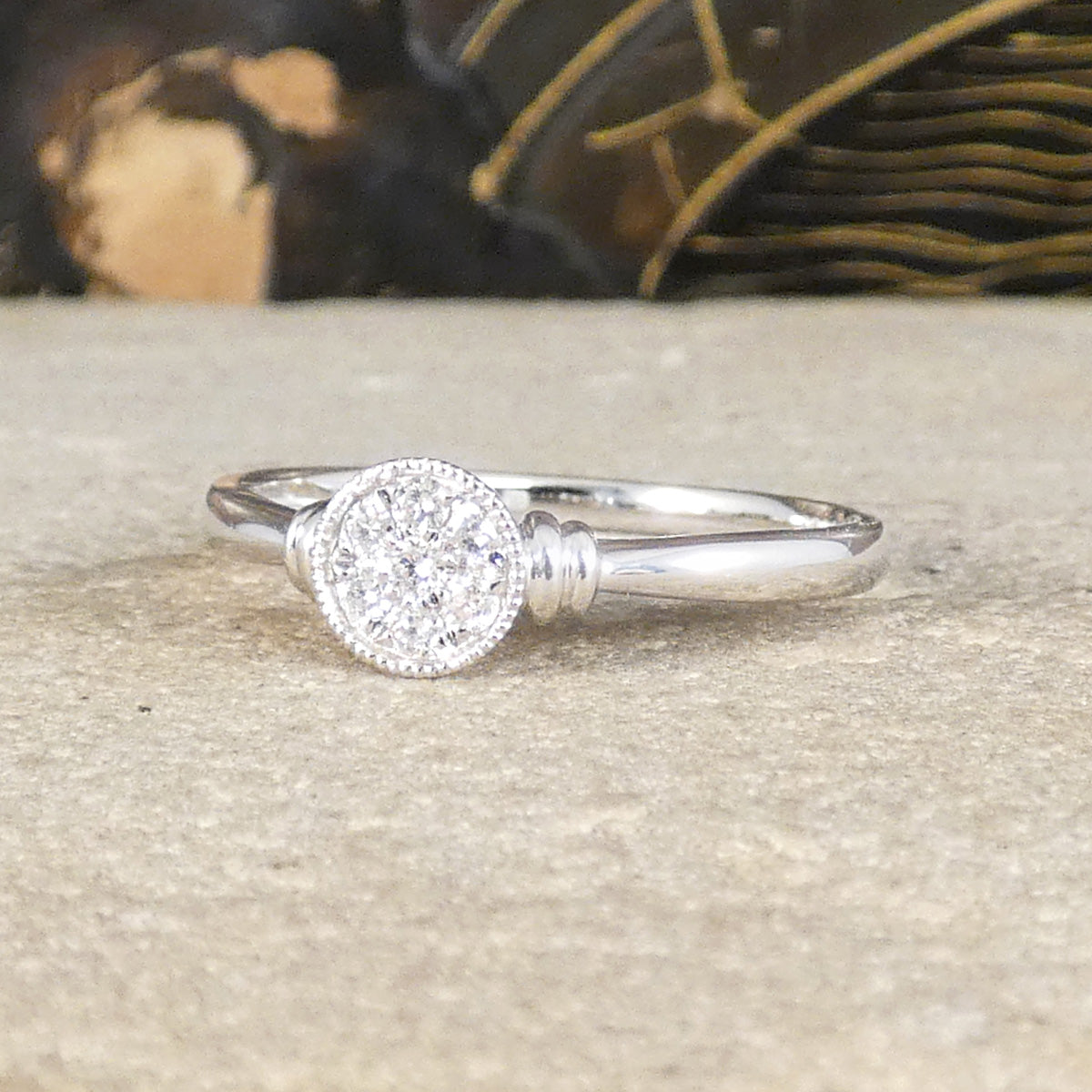 A diamond disc ring with a slight milgrain edge detail and plain polished band.