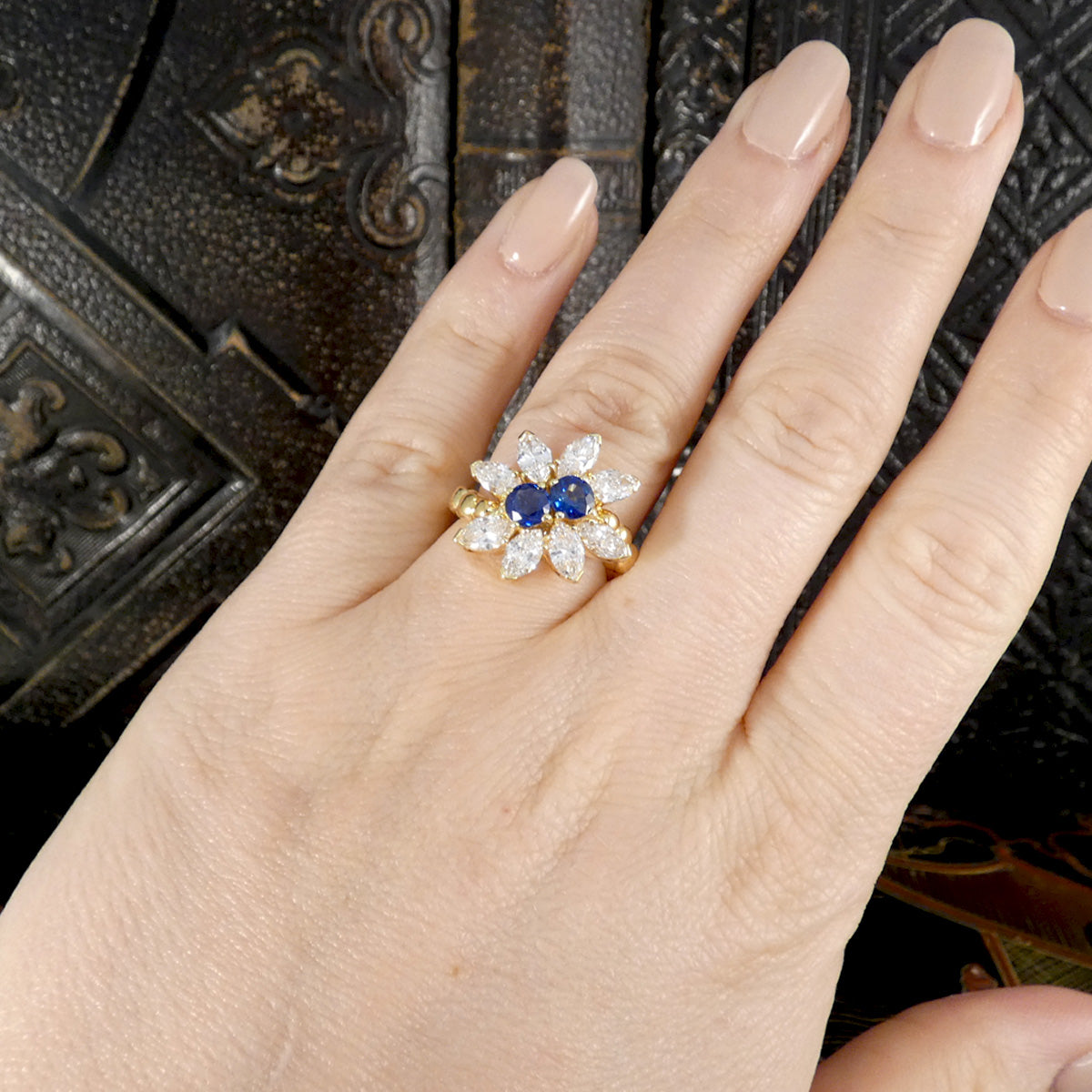 A unique Sapphire and Diamond ring made and designed by Kutchinsky displayed on the hand to see size and shape ratio.