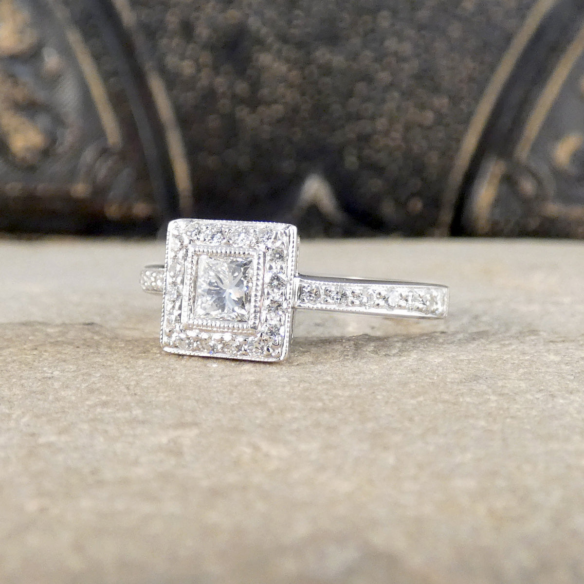 Silver ring with diamond accents on a textured surface