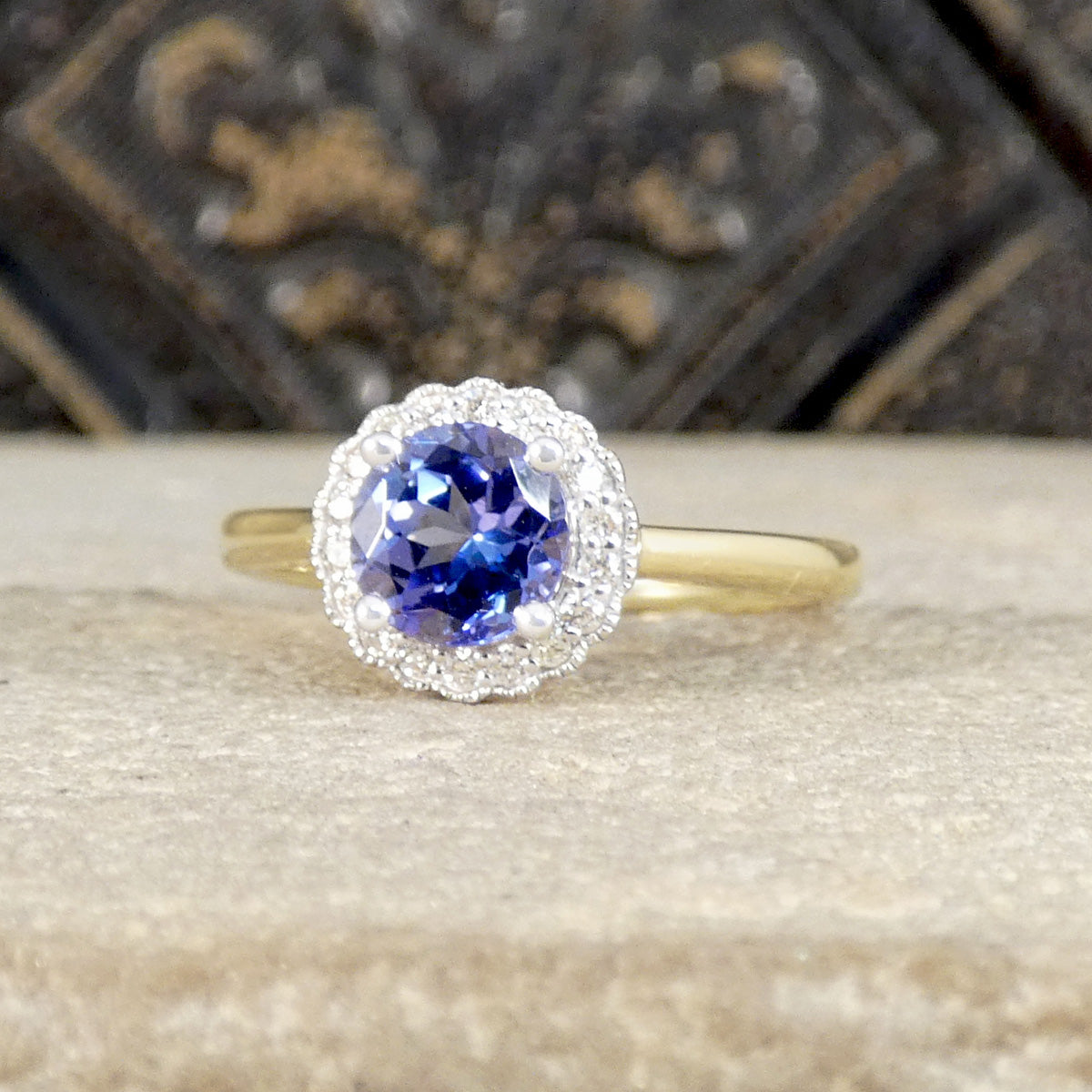 Gold ring with a blue gemstone on a textured surface