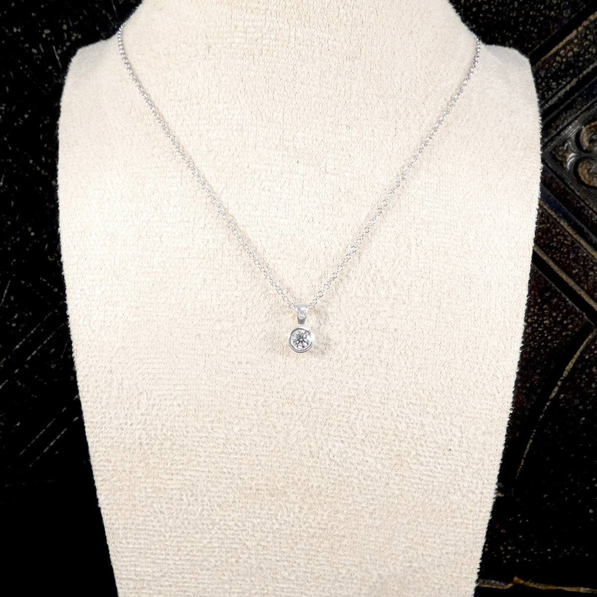 Necklace with a pendant on a mannequin bust against a dark background