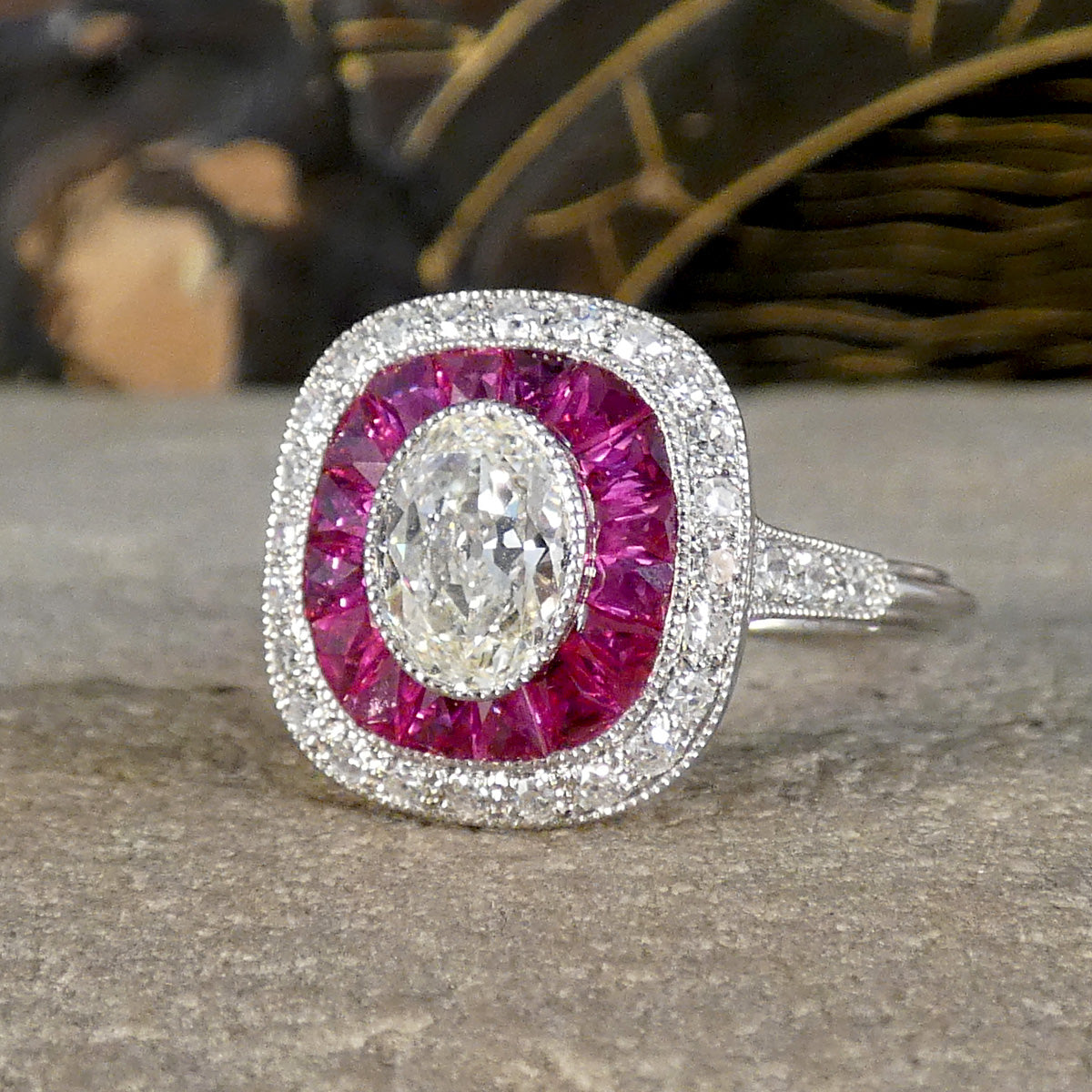 Art Deco Style Ruby and Oval Cut Diamond Target Cluster Ring in Platinum.