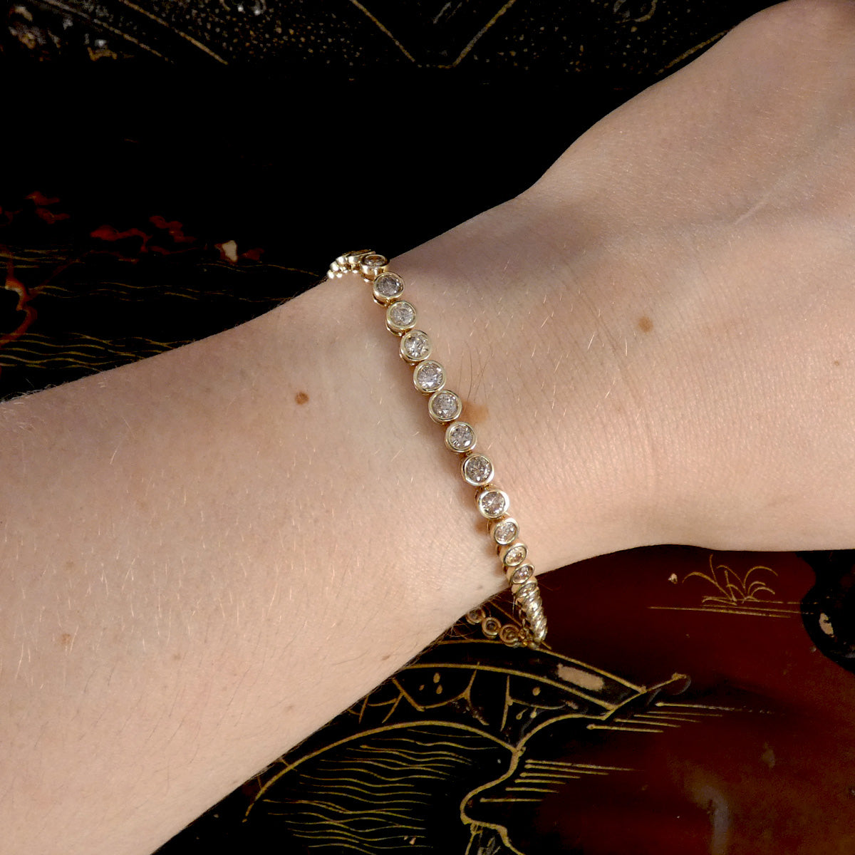 a diamond tennis bracelet being worn on someones arm.