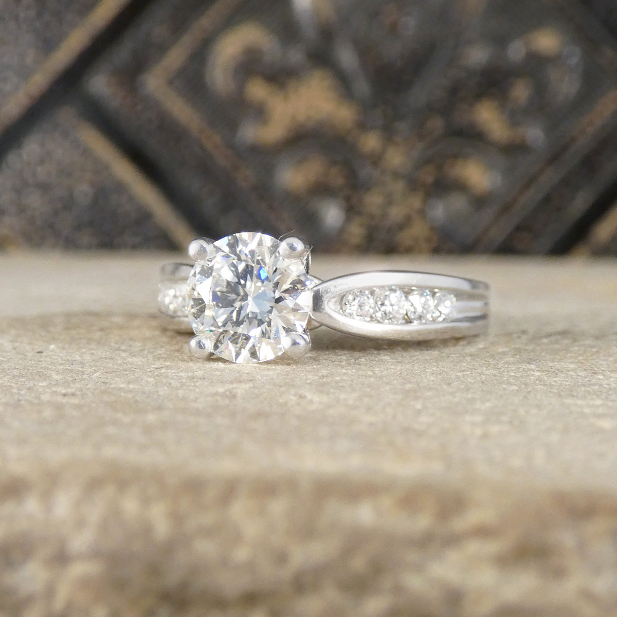 Silver Platinum ring with a large diamond and diamond shoulders on a textured surface