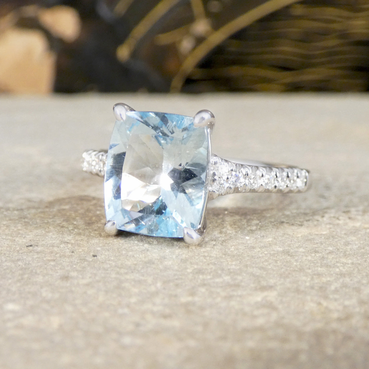 Silver ring with a large blue aquamarine gemstone on a textured surface