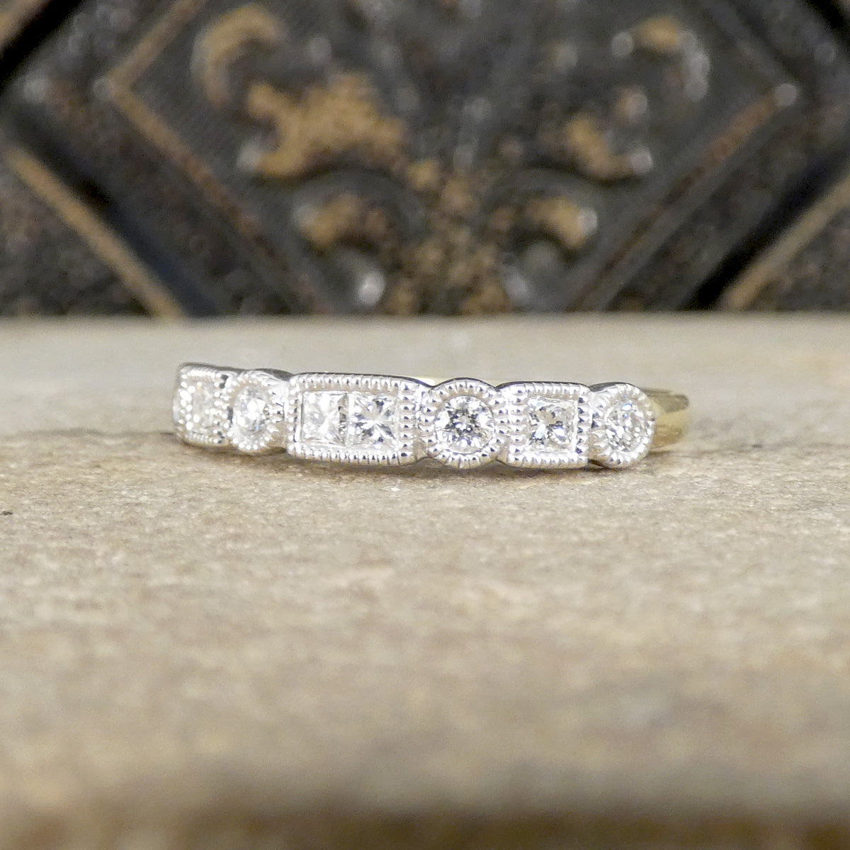 Diamond ring on a stone surface with a decorative background