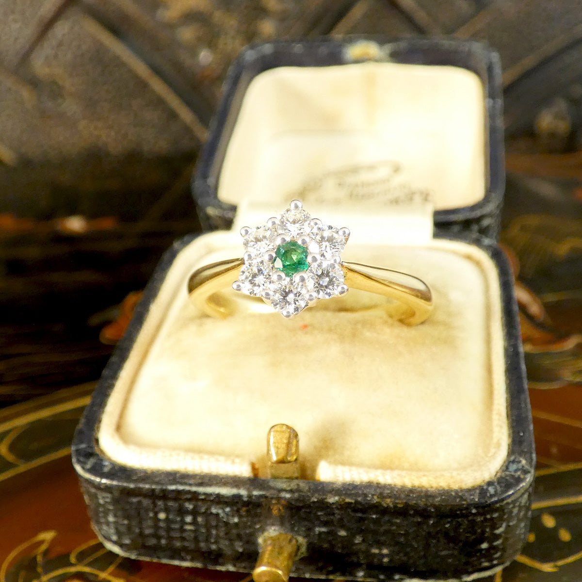 A beautiful and dainty Emerald and Diamond flower cluster ring in 18ct Yellow and White Gold displayed in vintage box.