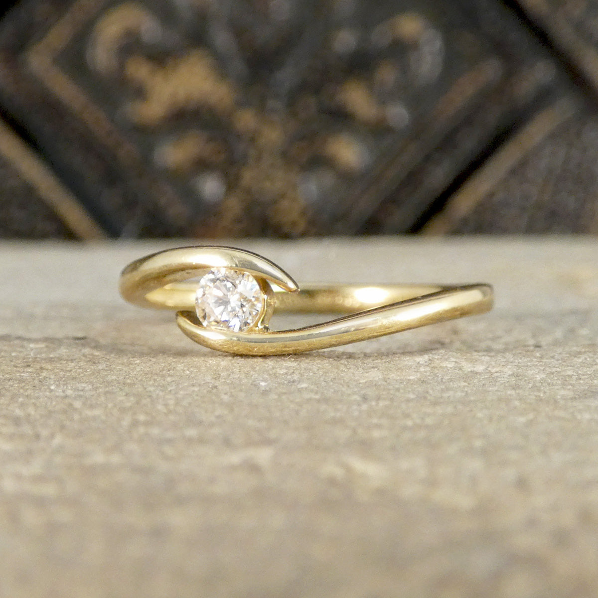 Gold ring with a diamond on a textured surface