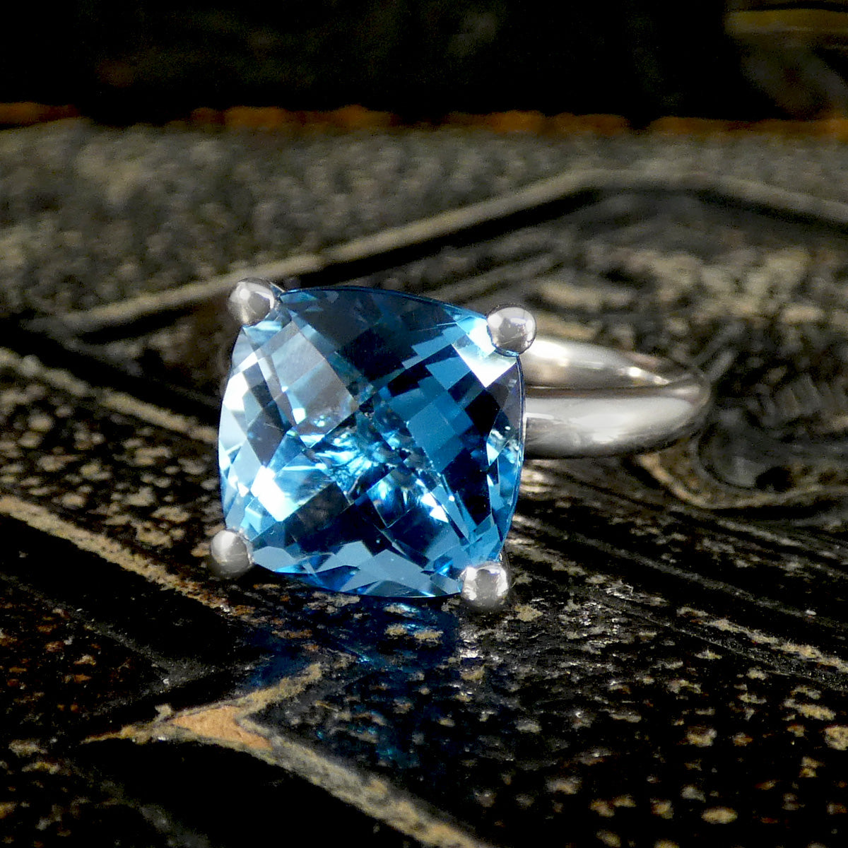 Silver ring with a blue gemstone on a textured surface