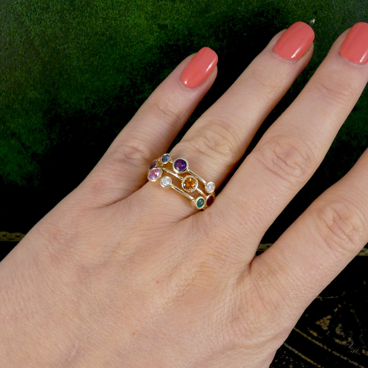 Multi Gem set bubble ring in yellow gold displayed on the hand on the ring finger