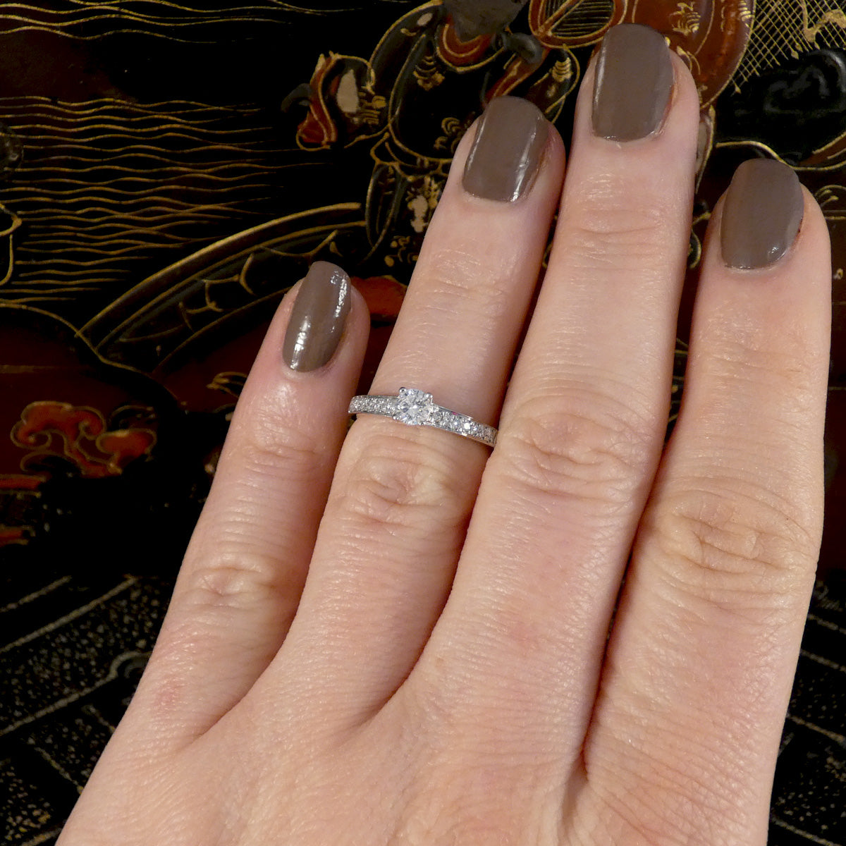 Hand with a diamond ring on a decorative background