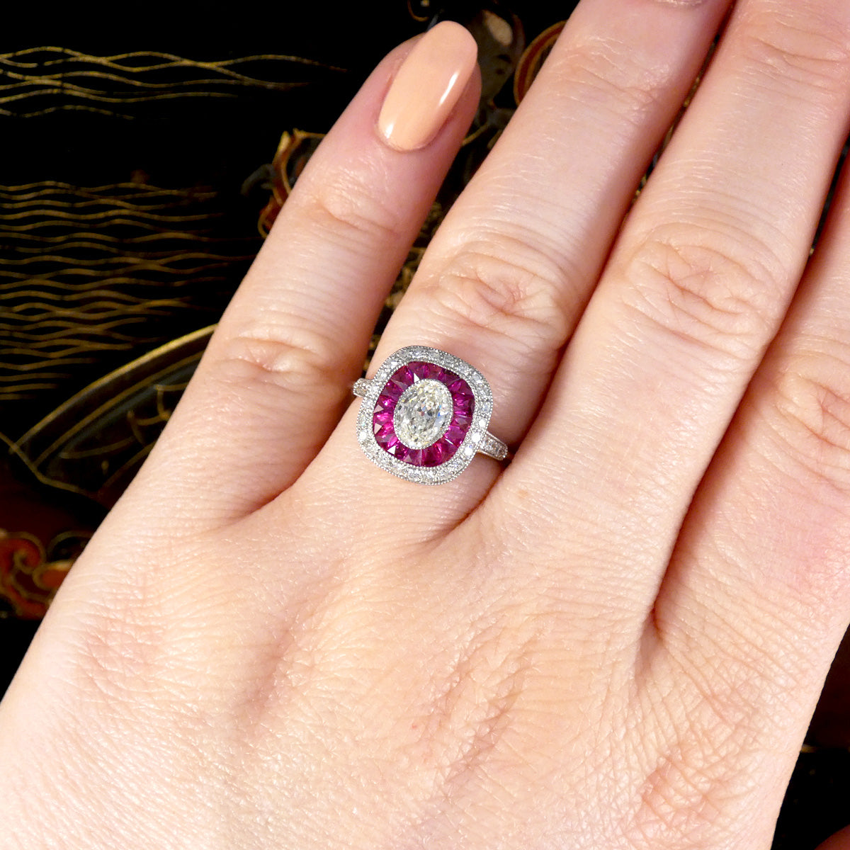 Art Deco Style Ruby and Oval Cut Diamond Target Cluster Ring in Platinum shown on hand to see size ratio and reference. 