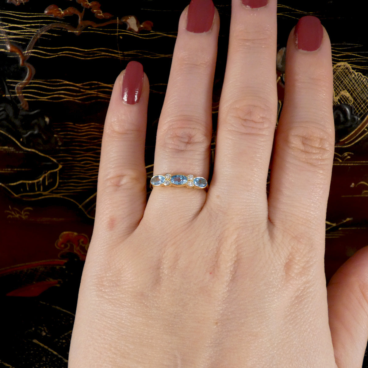 Blue Topaz and Diamonds ring in Yellow Gold shown on the hand 