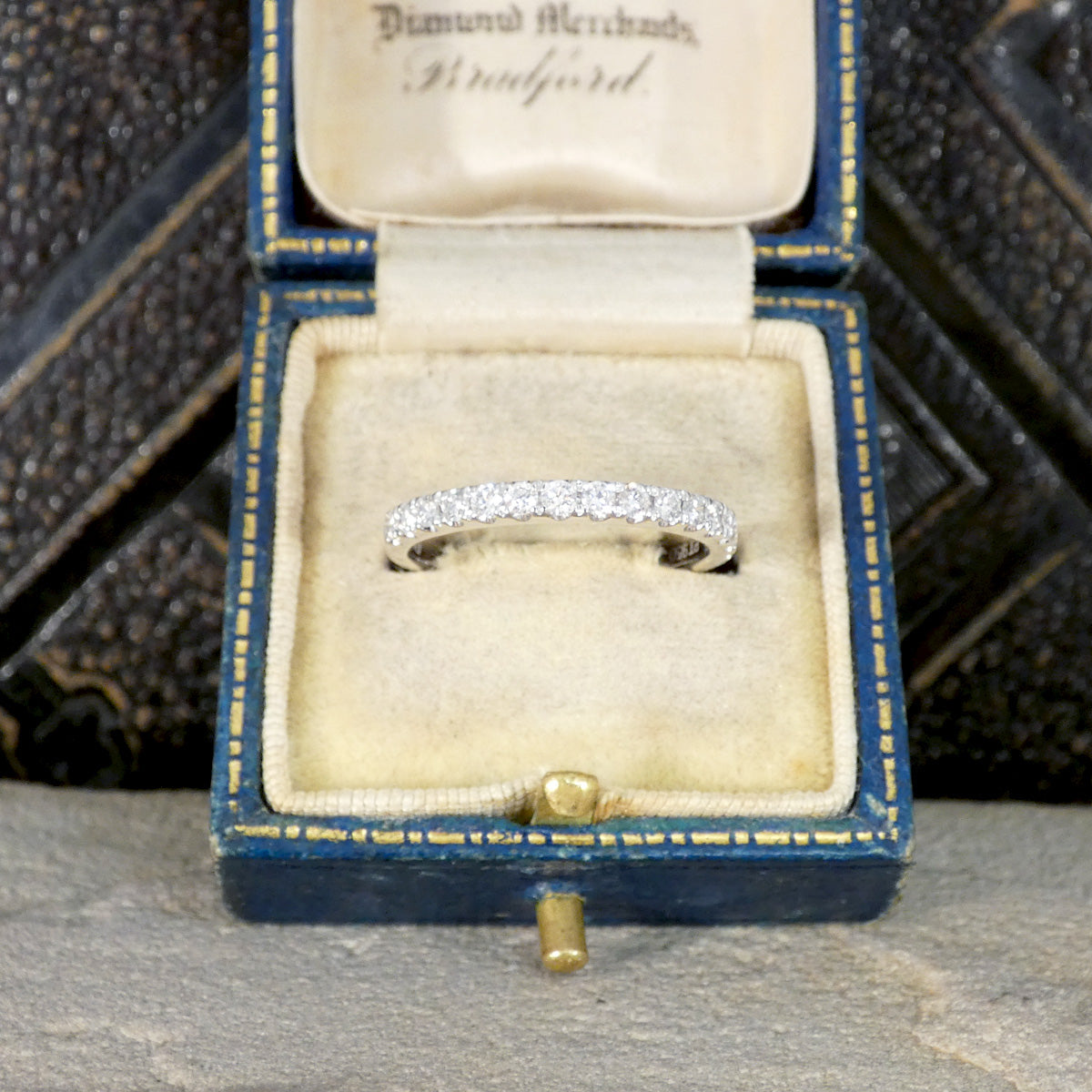 Diamond ring in a blue jewelry box.