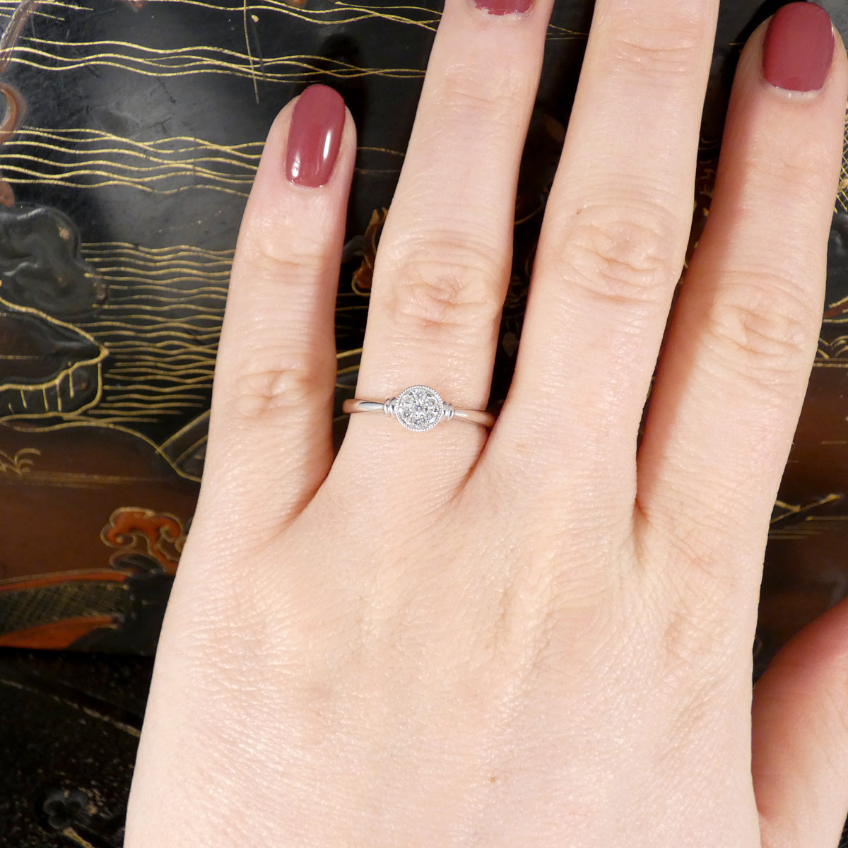 A diamond set disc shaped cluster ring with a double donut shoulders in Platinum. Shown worn on the finger to see size ratio.