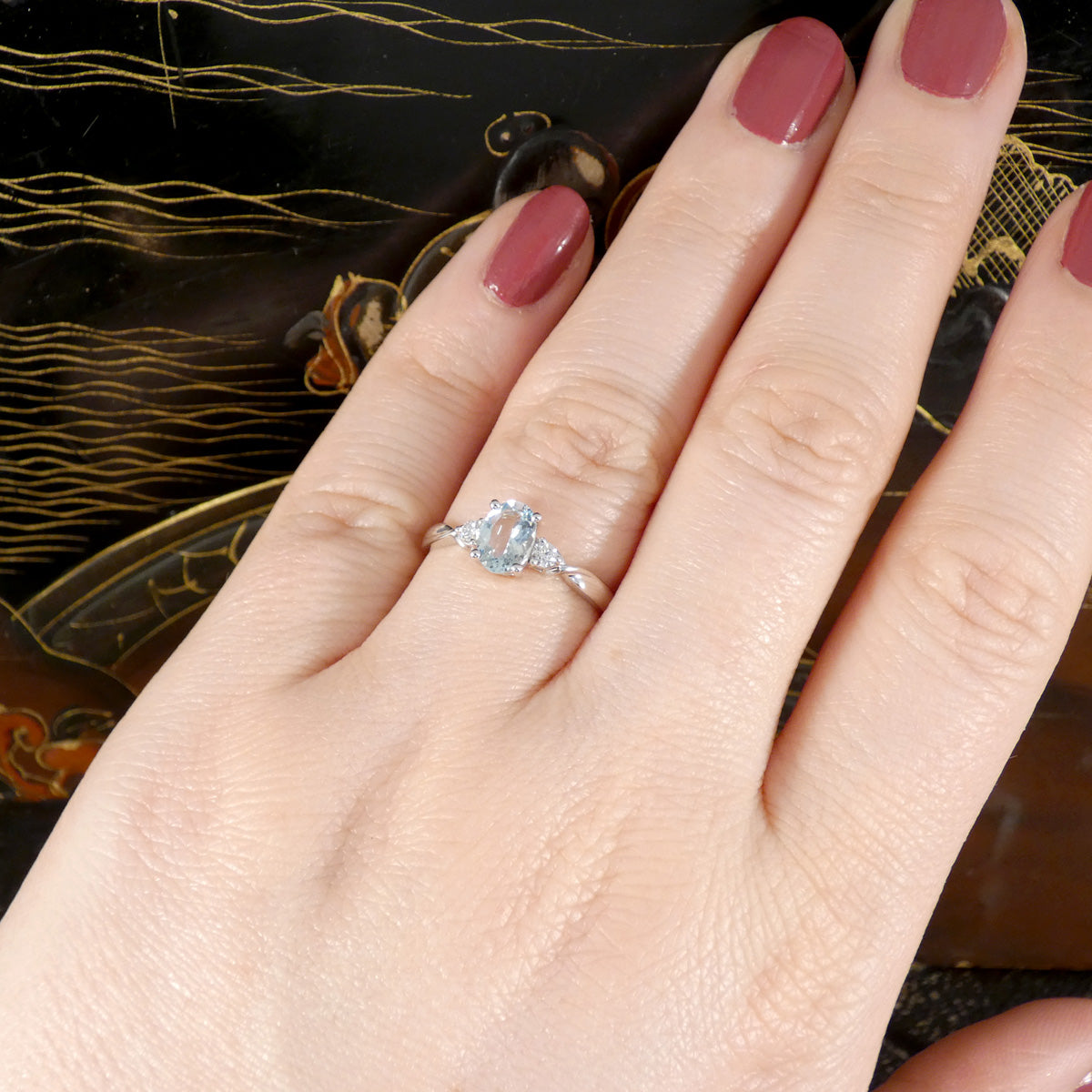 Modern Oval Cut Aquamarine and Brilliant Cut Diamond Three Stone in Platinum. Shown worn on the finger to see colour and size.