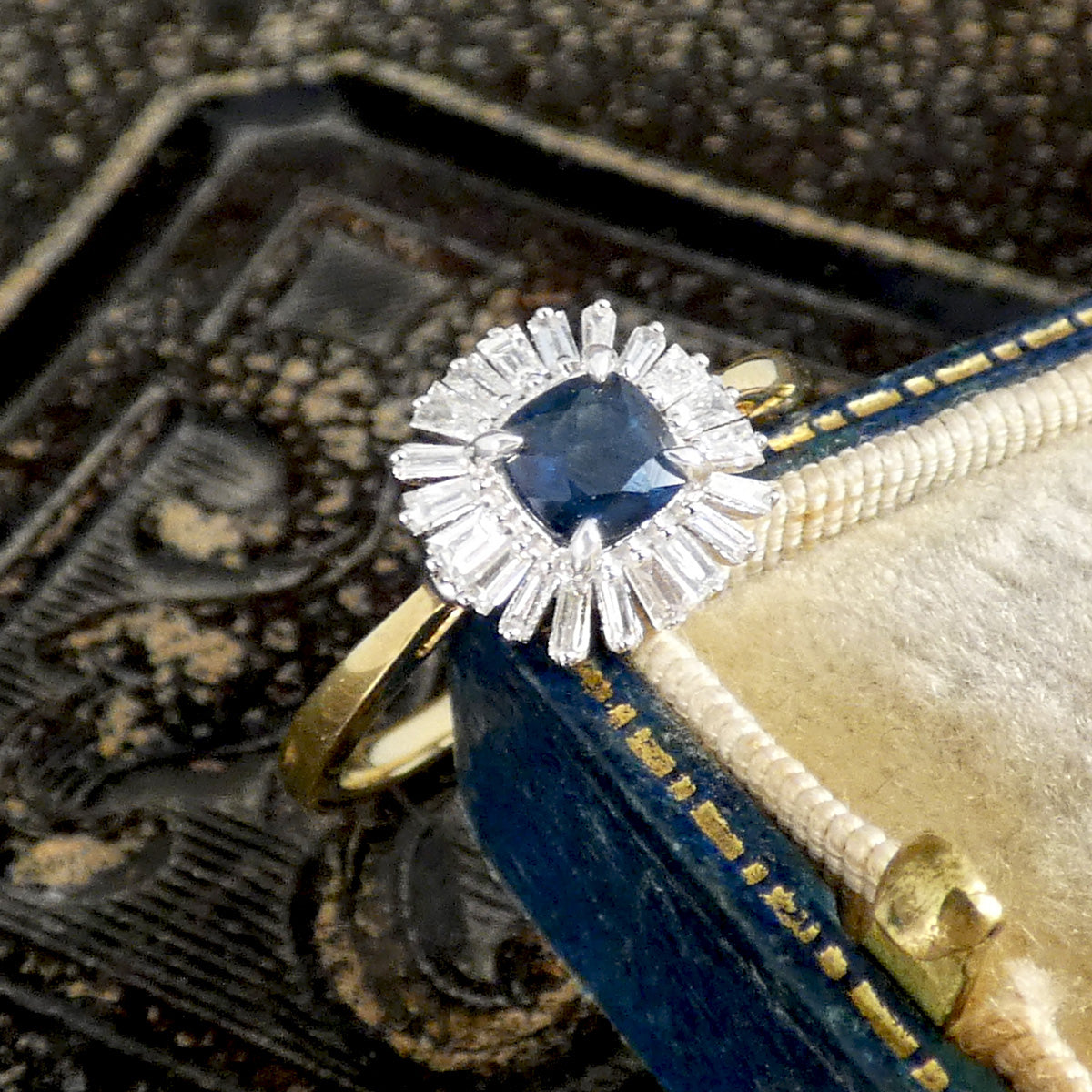 A gorgeous gift idea, this sapphire and diamond cluster ring shown leaning on a vintage box.