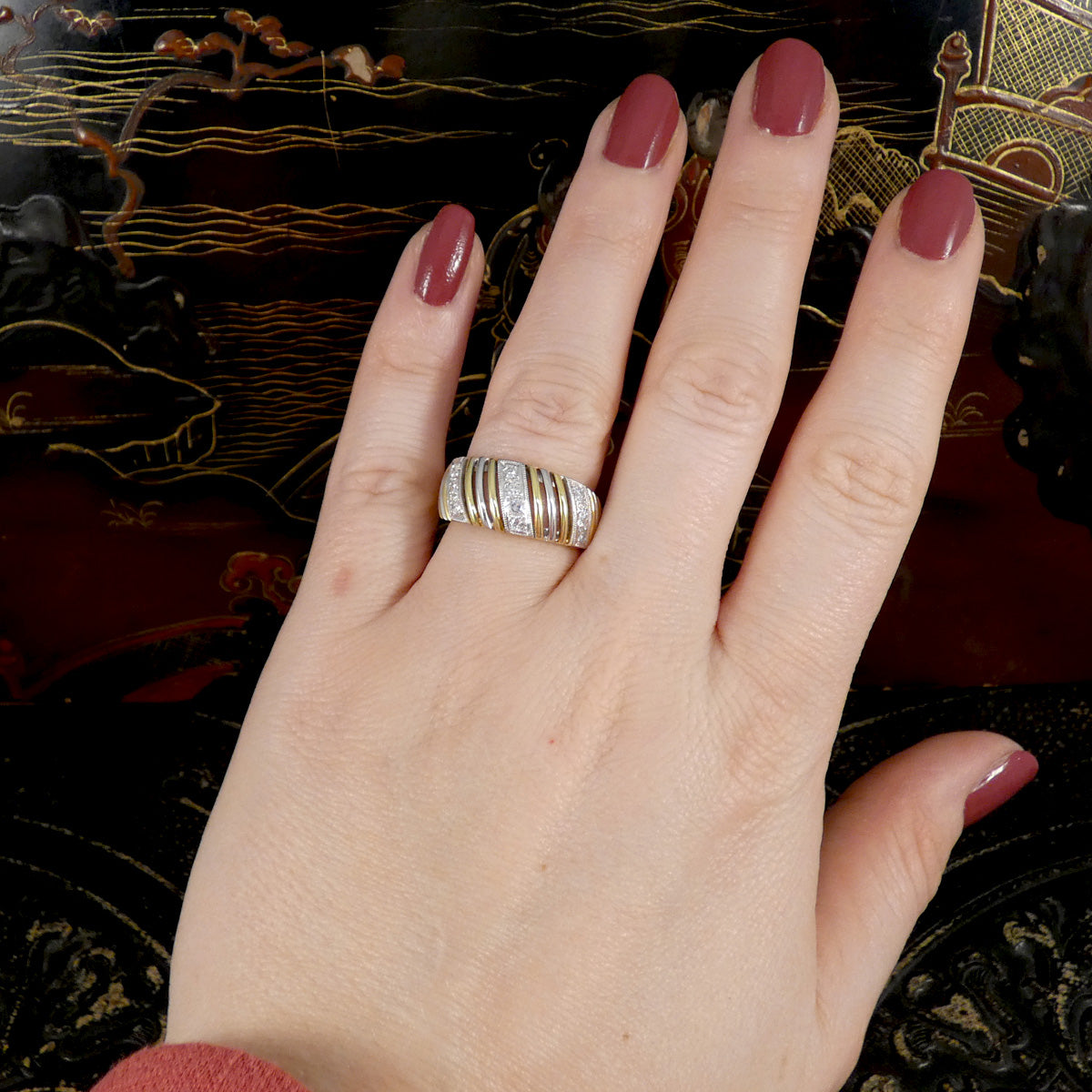 a chunky diamond set gold ring worn on the finger