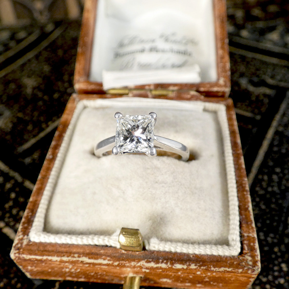 A gorgeous princess cut diamond sapphire ring shown in a vintage box.