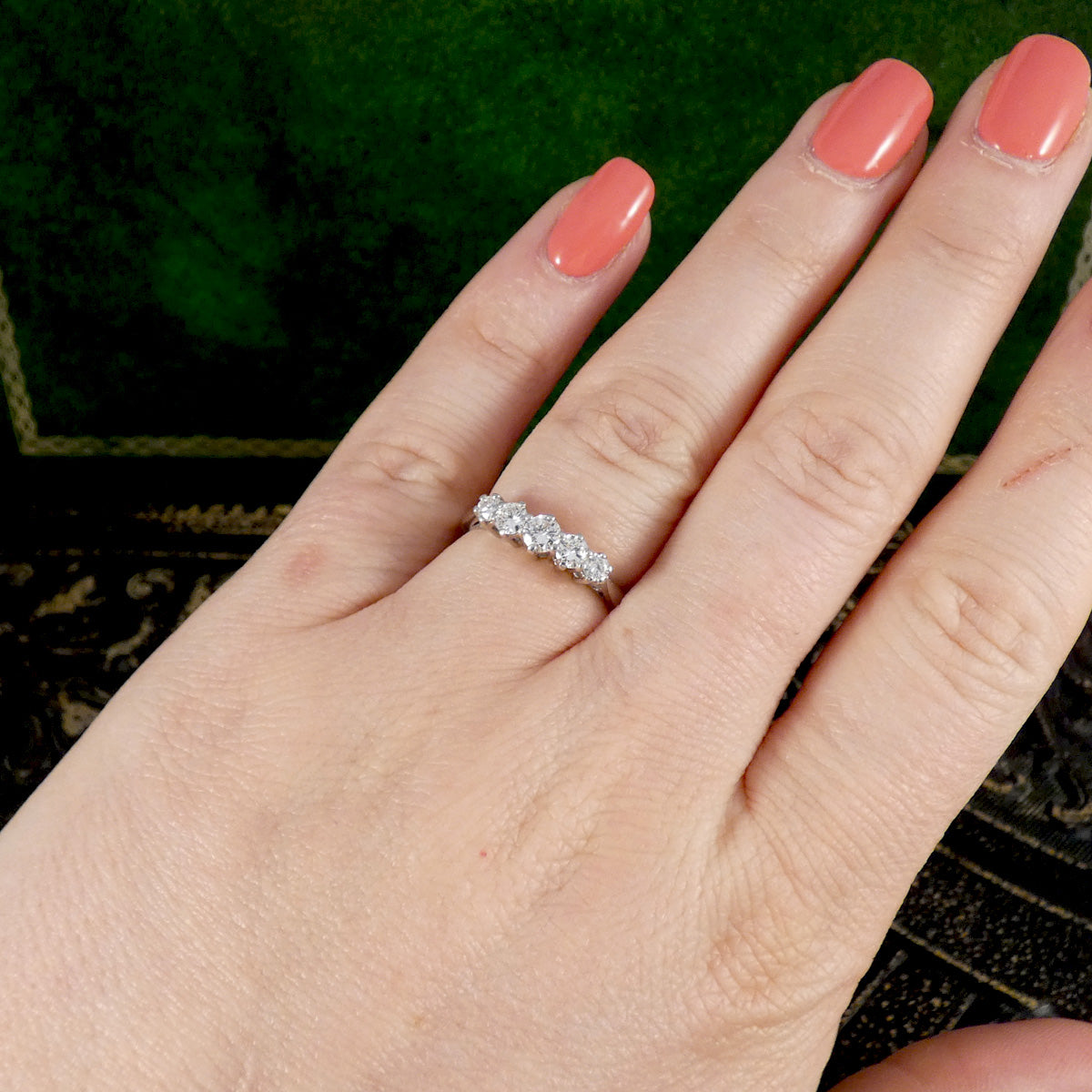 A diamond five stone graduated ring shown on the hand.