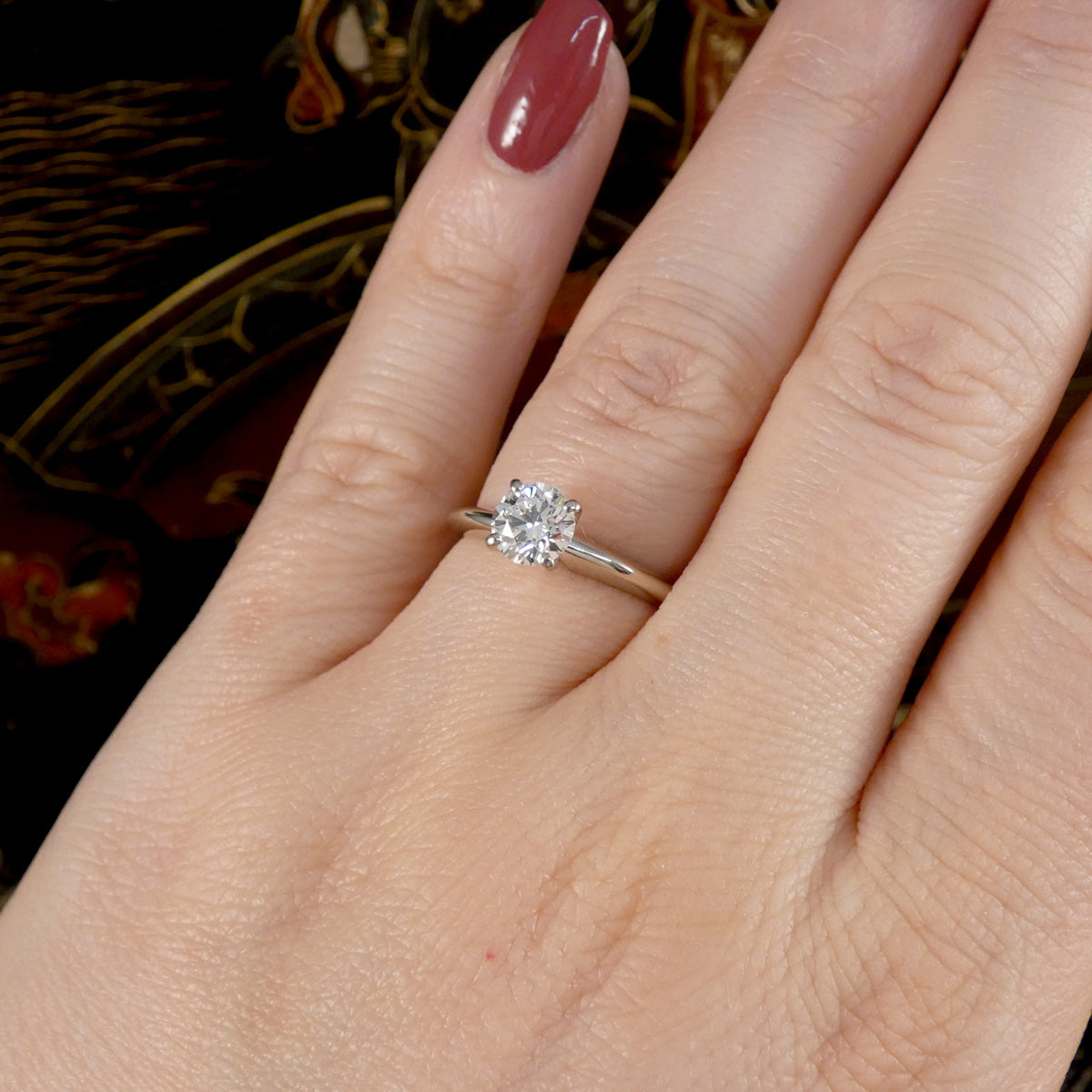 A diamond solitaire high set ring in white gold shown on the hand on the wedding finger as an engagement ring