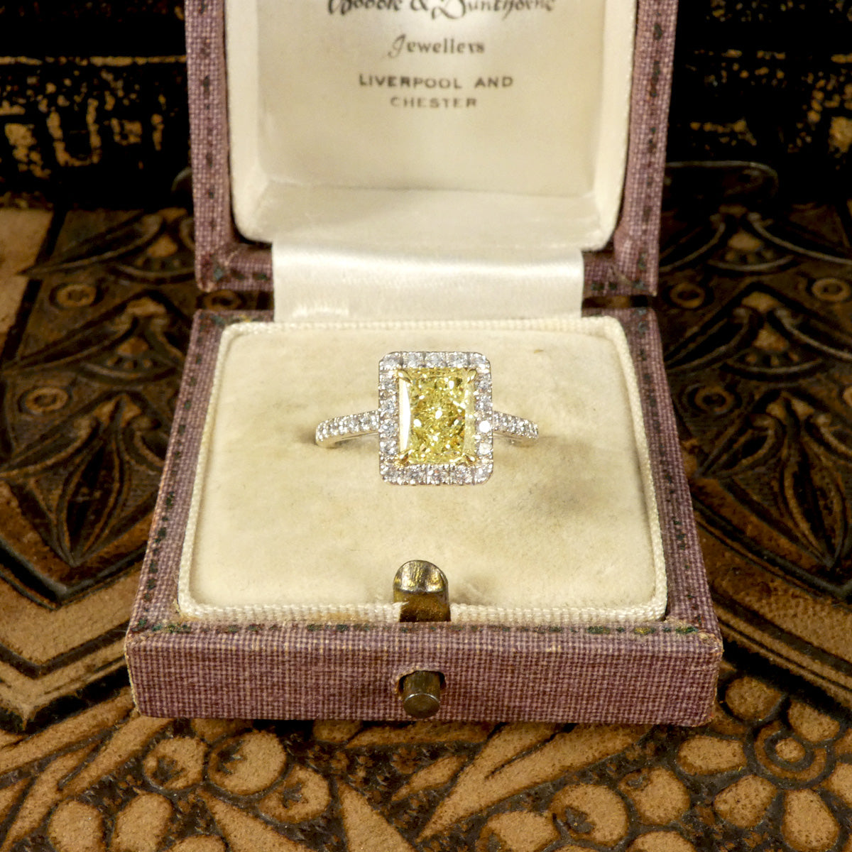 Natural Yellow Radiant Cut Diamond with GIA grading in a four claw setting. Surrounded by a halo of bright white Diamonds and Diamond set shoulders in 18ct White Gold. Perfect engagement ring. Shown in vintage box.