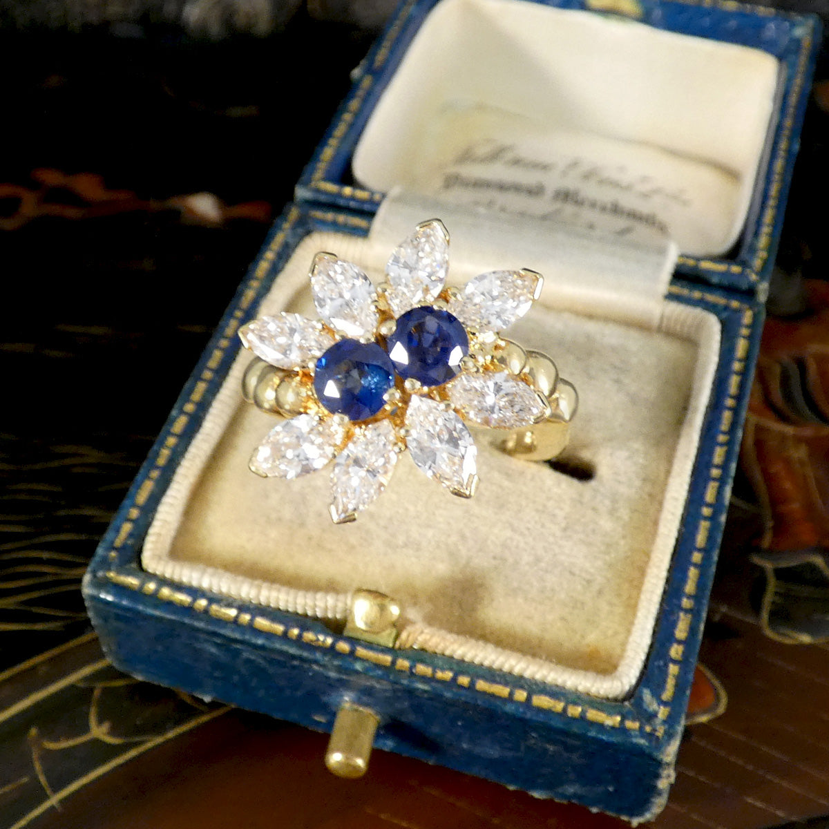 A sapphire and diamond later twentieth century ring displayed in a vintage box.