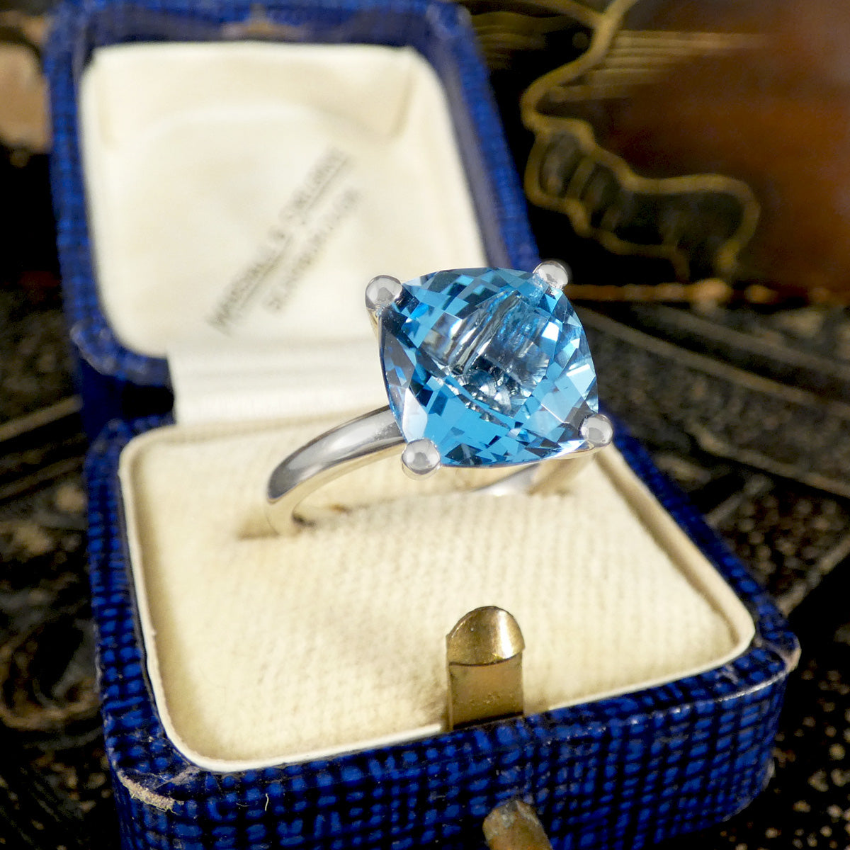 Blue gemstone ring in a blue box with a blurred background