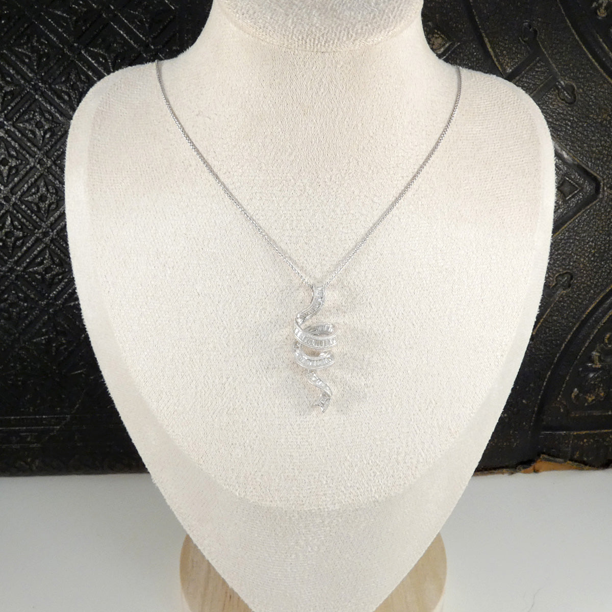 White Gold Diamond necklace on a mannequin bust with a textured black background