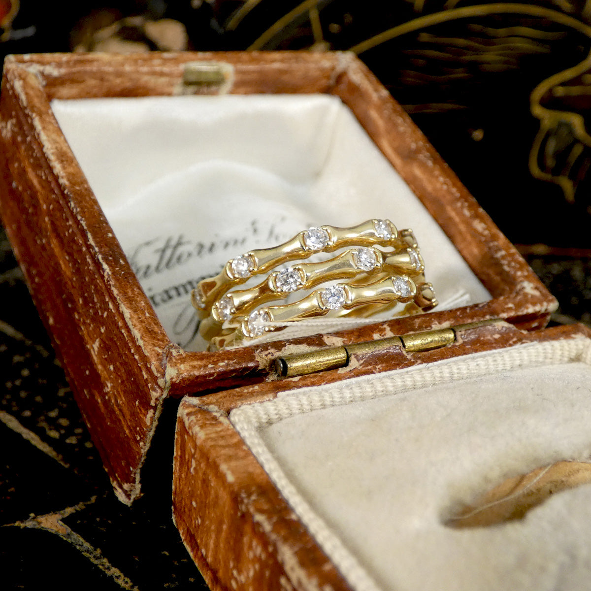 Three strand bamboo style ring in yellow gold with diamonds displayed in jewellery box