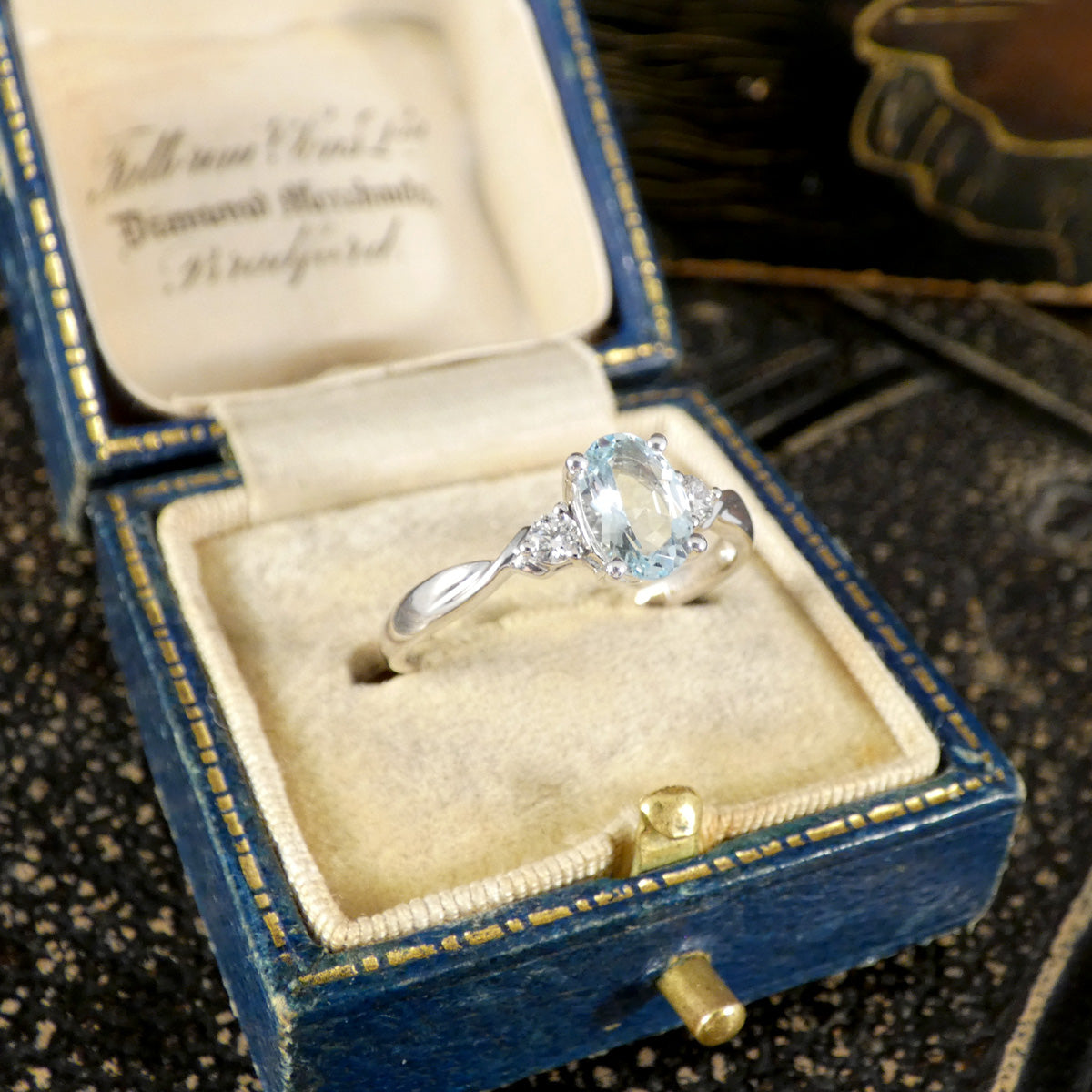 Modern Oval Cut Aquamarine and Brilliant Cut Diamond Three Stone in Platinum displayed in vintage box.