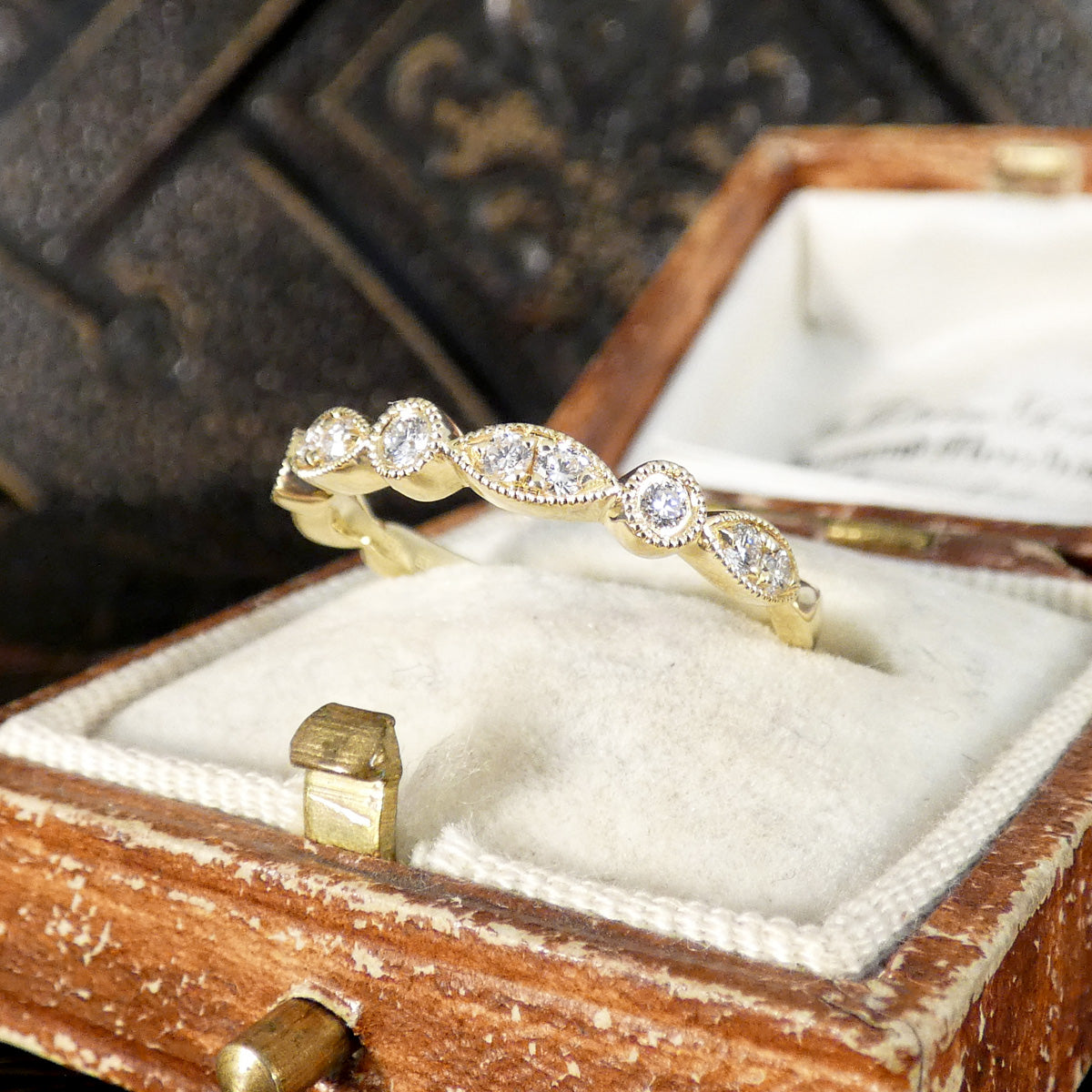 Gold ring with diamonds in a wooden jewelry box