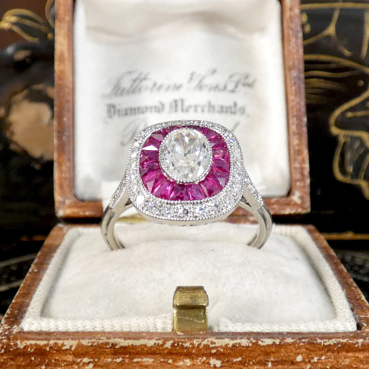 Art Deco Style Ruby and Oval Cut Diamond Target Cluster Ring in Platinum showing vibrant colour. The perfect gift for a vintage lover.