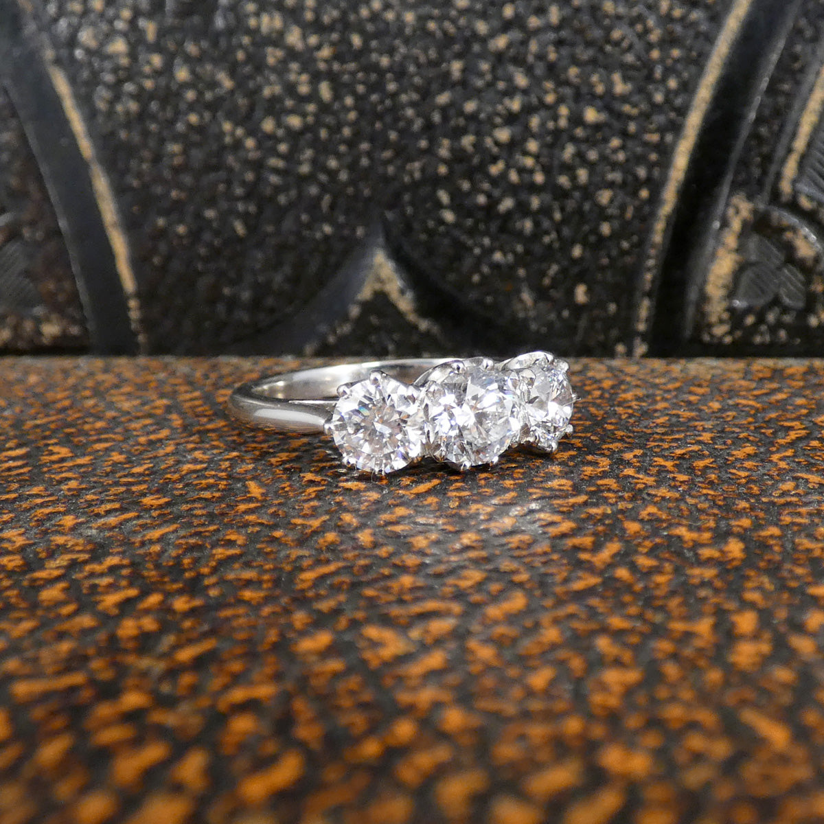 Diamond ring on a textured surface with a blurred background