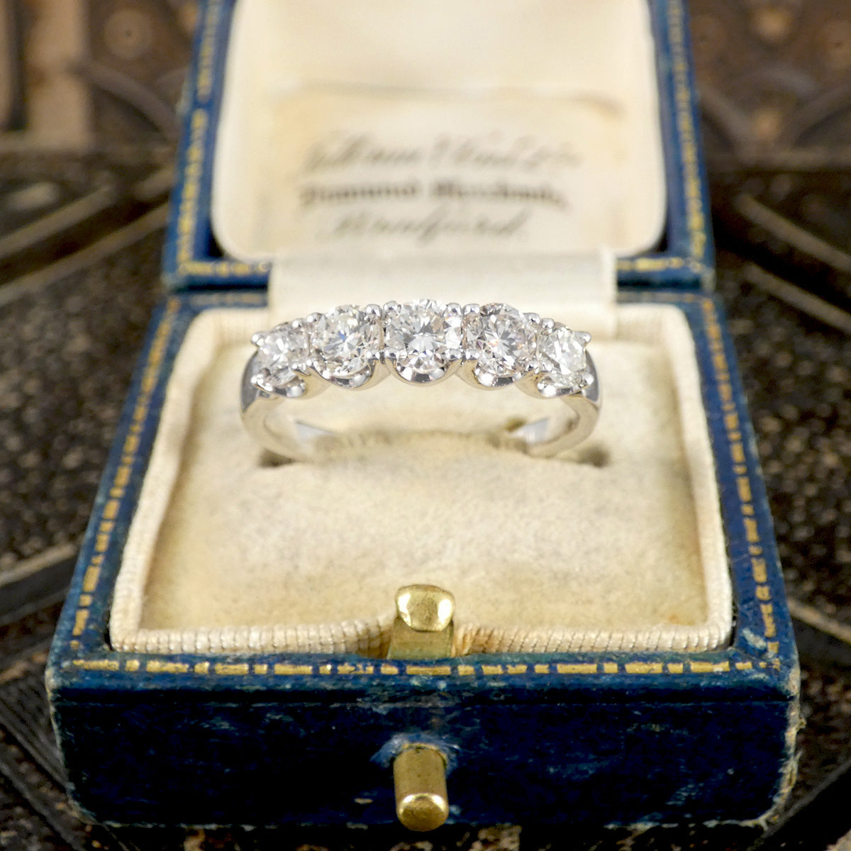 Diamond ring in a blue velvet box with gold accents